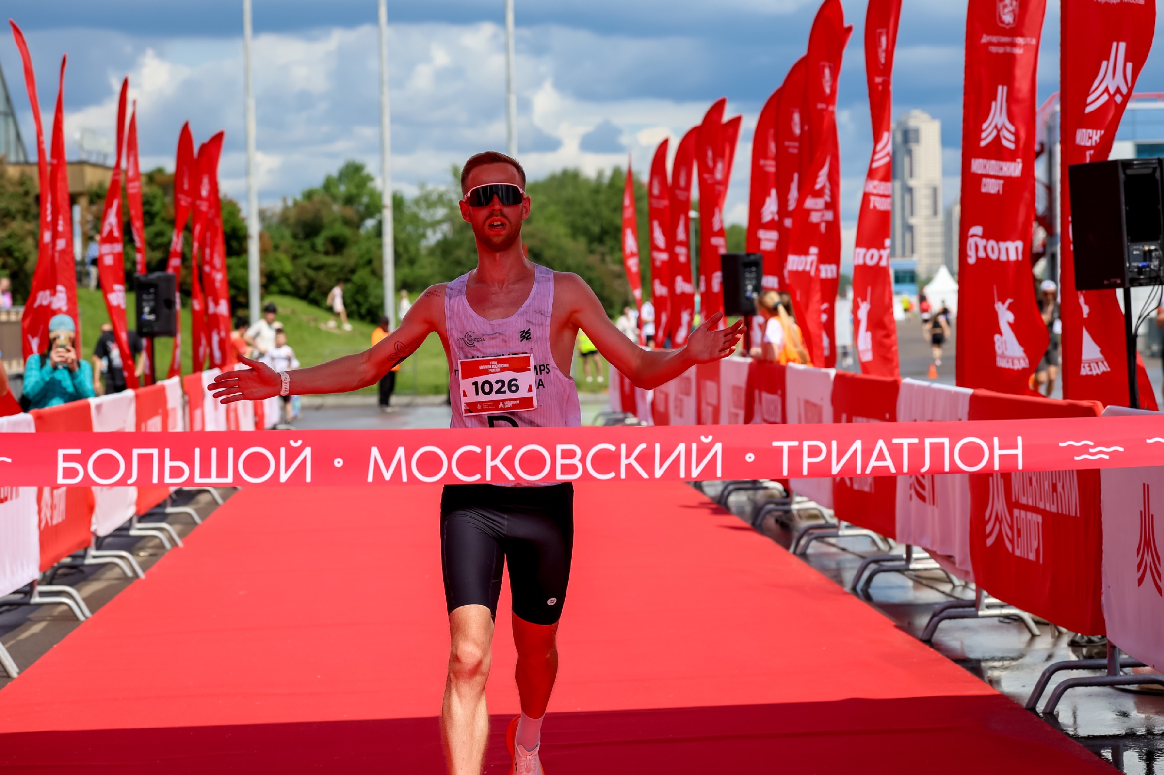 Максим Кубышко пересекает финишную ленту с поднятыми руками